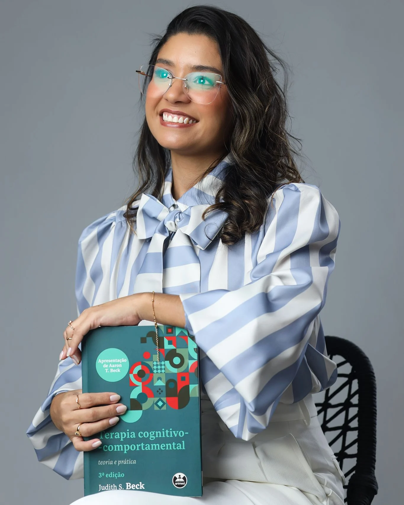 Herlania Fernandes com o manual de Terapia Cognitivo-Comportamental de Judith Beck
